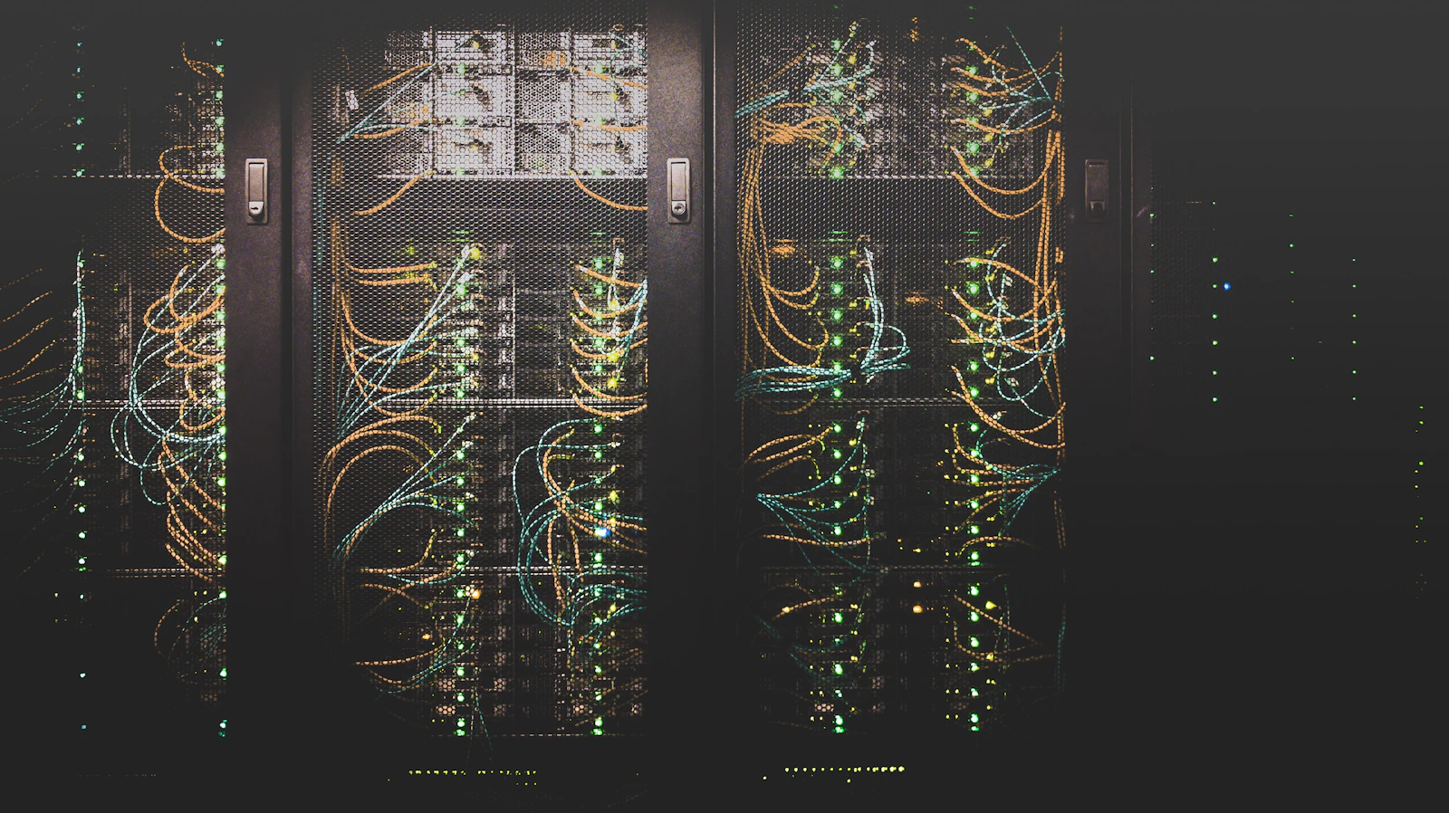 Corredor de um data center com fileiras de servidores iluminados.